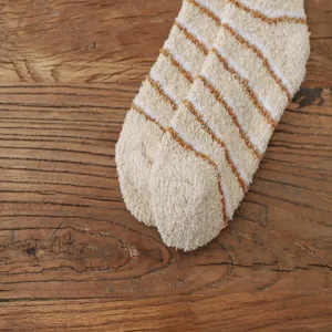Detail shot of cozy thickened coral fleece striped fuzzy socks, soft and warm for winter home.