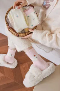 Vue détaillée de chaussettes en laine duveteuse et douillette avec motif d'animal mignon.