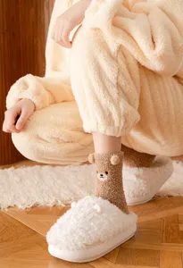 Detail view of cute winter plush bear socks with 3D ears and fluffy slippers for cozy home wear.