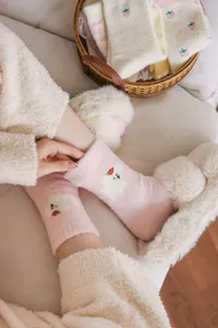 Chaussettes douillettes roses et duveteuses avec joli motif pour l'hiver chaleureux.
