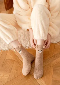 Cozy fleece winter socks detail showing cute 3D bear ears and soft plush fabric texture.