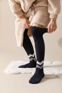 Detailed shot of thick fluffy over-the-knee winter socks with cozy texture and cozy chevron design.