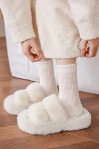 Vue détaillée de chaussettes douillettes rose d'hiver en peluche avec chaussons duveteux.