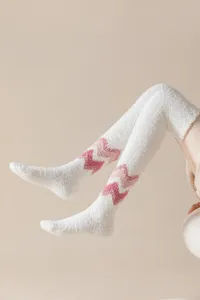 Fluffy over-the-knee coral fleece socks detail view, soft white winter warm fuzzy stockings with pink chevron patterns.