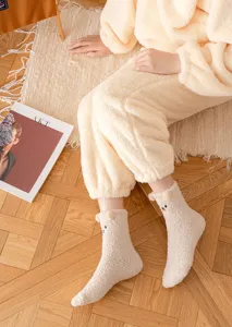 Cozy winter fleece socks featuring cute cartoon bear design and soft plush pom-pom ears detail.