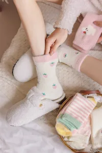 Détail de chaussettes d'hiver pelucheuses, motif de fraise mignon, tissu chaud et doux en peluche.