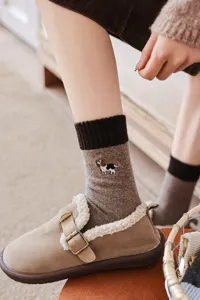 Calzini in lana autunno-inverno con ricamo di cucciolo e dettagli marroni a contrasto.