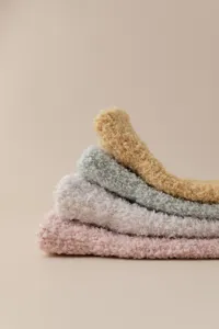 Close-up of soft fluffy coral fleece cozy winter socks, showing warm plush texture details.