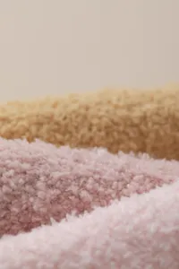 Close-up detail of soft coral fleece winter warm socks texture, cozy fabric macro shot.