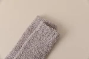 Close-up detail of soft grey coral fleece winter warm long socks, thick plush fabric texture.