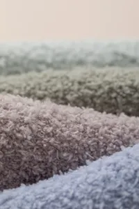 Close-up detail shot of soft fluffy coral fleece winter over-the-knee socks texture.