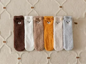 Detail shot of cute bear plush fuzzy socks, soft coral fleece winter home floor socks.