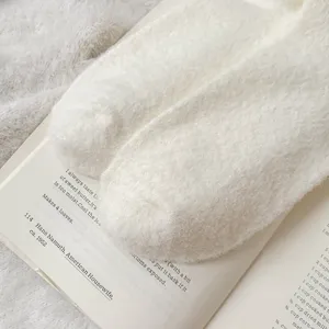 Chaussettes d'hiver douillettes et épaisses en blanc, peluche douce pour garder au chaud.