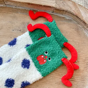 Vue détaillée de chaussettes d'hiver en polaire corail duveteuse avec broderie et antennes.