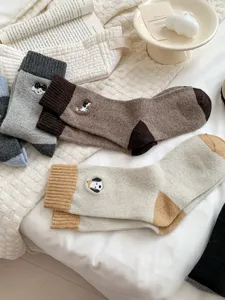 Dettaglio calze di lana autunno inverno, simpatico ricamo di animali, design a blocchi di colore.
