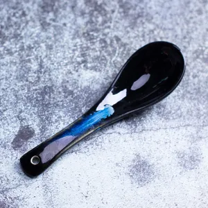 Ceramic soup spoon with kiln-changing blue glaze, long handle detail, modern tableware.