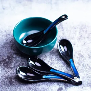Ceramic spoon and bowl detail shot, black kiln-change glaze with blue accent for table.