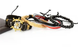 Close-up of handmade nautical braided bracelet set featuring metal helm, leather and beads.