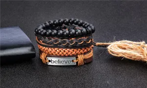 Set de pulseras de cuero multicapa con cuentas negras y placa metálica con grabado.