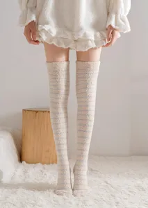 Cozy winter fuzzy over-the-knee striped socks detail, soft coral fleece home wear design.