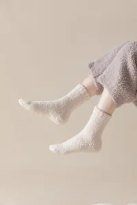 Soft coral fleece fuzzy lounge socks with anti-slip silicone soles for cozy indoor wear.