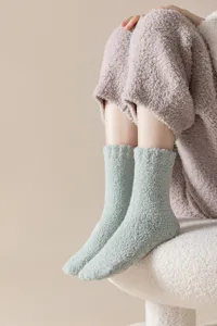 Close up of soft coral fleece cozy fuzzy sleep socks detail in light green color.