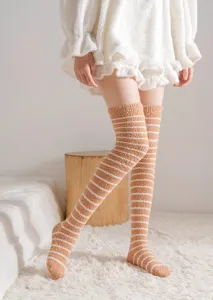 Close-up detail of cozy brown and white striped over-the-knee coral fleece socks.
