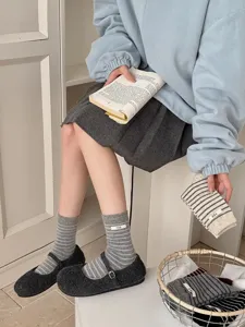 Detail view of Korean style grey striped women wool socks featuring a cute brand label patch.