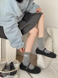 Detail shot of grey striped women's socks featuring a cute egg label and cozy cashmere feel.