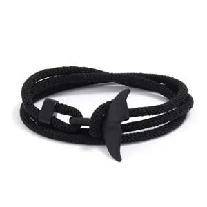 Close-up detail of the black braided rope bracelet featuring a sleek whale tail charm.