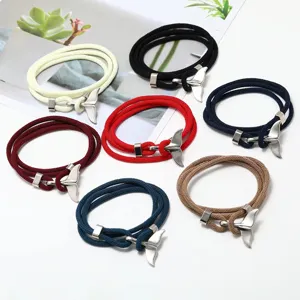 Details of multi-color woven rope bracelets with silver whale tail charms, variant showcase.