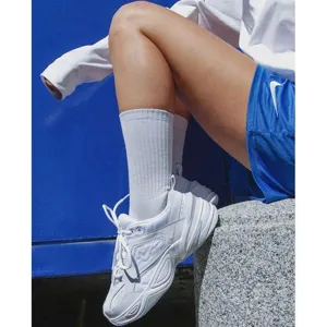 Detailed shot of white sports socks and sneakers worn by a model in outdoor lifestyle.