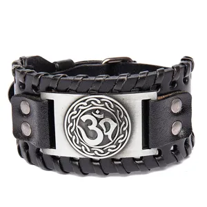 Men vintage braided leather cuff bracelet with metallic Om symbol charm and sturdy rivets.