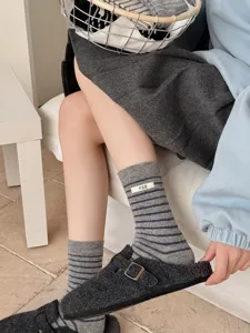Detail view of Korean style wool blend striped mid-calf socks with egg fabric label.