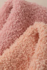 Close-up detail of soft coral fleece fabric, fluffy texture, cozy and warm for winter wear.