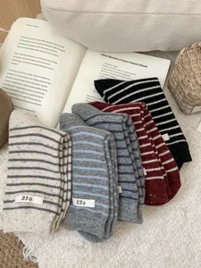 Detail view of cozy striped wool cashmere slouch socks with small label, simple winter wear.