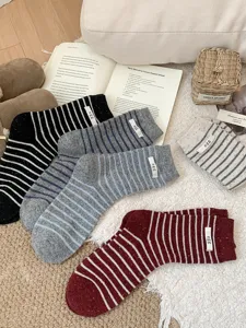 Cozy wool striped crew socks for women, Korean style winter warm knit casual hosiery with cute label.