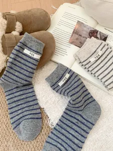 Korean style striped wool socks detail shot featuring cute egg fabric label and soft warm knit.