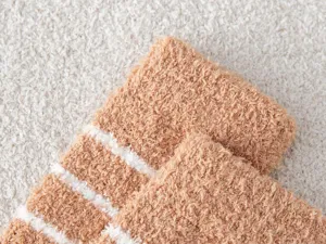 Close-up detail of soft cozy coral fleece winter striped socks, showing thick fabric.