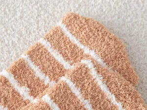 Close-up of thick coral fleece striped over-the-knee socks showing soft texture details.