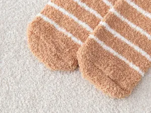 Close-up of cozy brown and white striped coral fleece fuzzy winter socks for home wear.