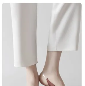 Detail view of women's invisible strap low-cut socks worn with white pants for summer.