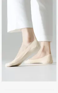 Detailed side view of beige low-cut invisible liner socks worn with white pants, soft cotton.