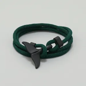 Dunkelgrünes geflochtenes Armband mit schwarzem Walflossenverschluss im maritimen Design.