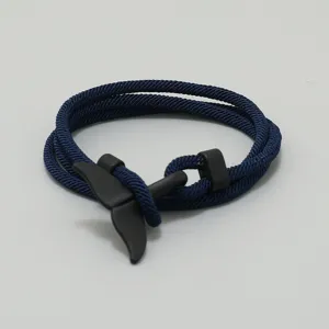 Detailaufnahme des dunkelblauen geflochtenen Armbands mit einem schicken Walfischschwanz.
