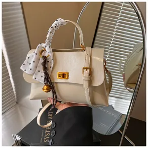 Chic off-white square shoulder bag with elegant polka dot scarf and cute bell charm detail.