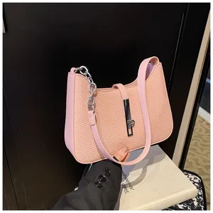 Detailansicht der rosa gewebten Schultertasche mit Metallkette und stilvollem Verschluss.