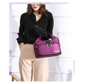 Detailed view of large capacity purple nylon women handbag worn by model in studio.