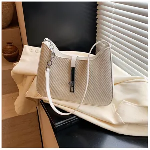 Detailansicht der modischen Schultertasche mit Stroh-Textur und elegantem Metallschloss.