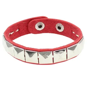 Detalle de la pulsera de cuero rojo punk con tachuelas piramidales cuadradas plateadas.